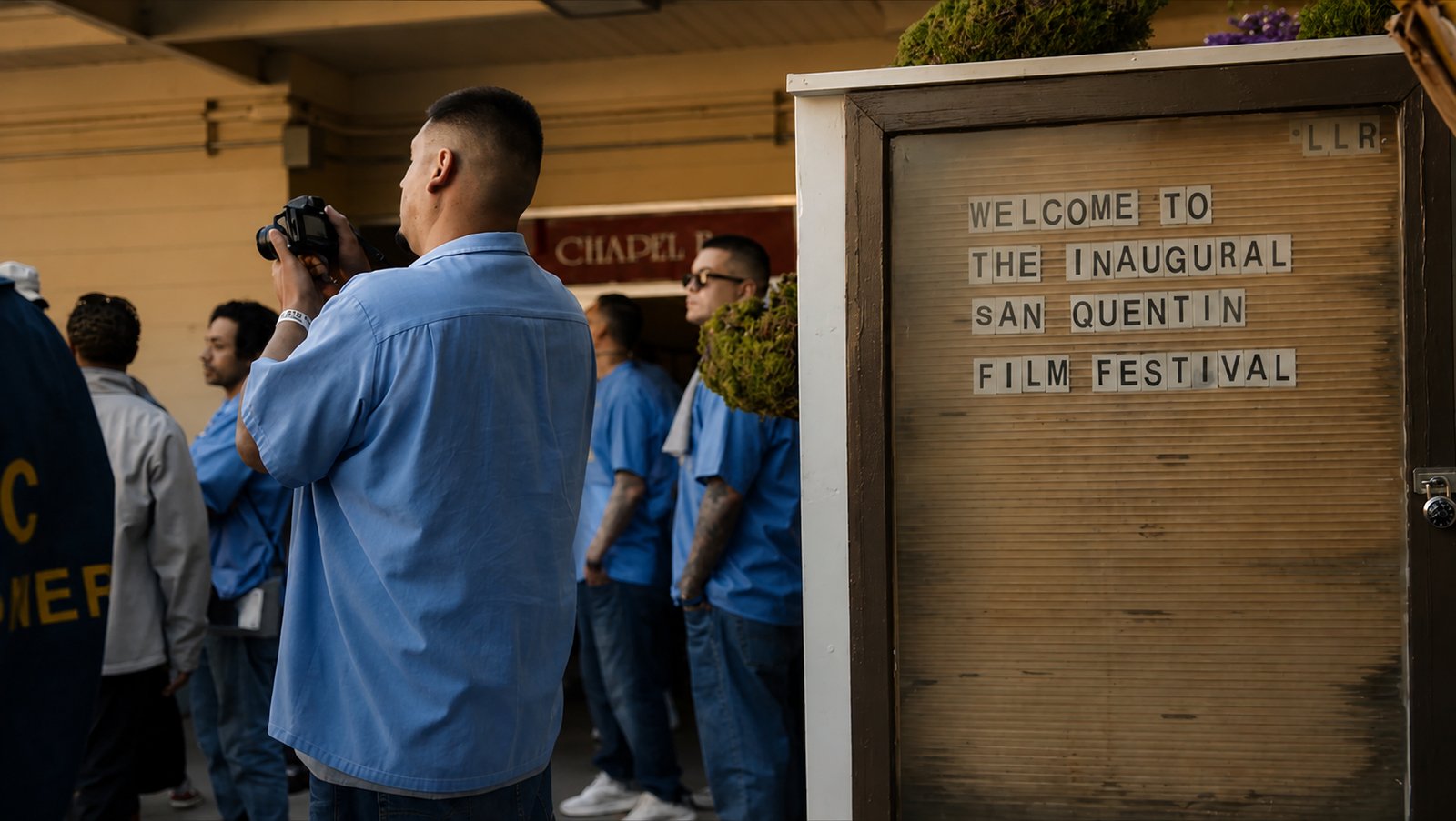 A man in blues photographs the letterboard welcoming guests to the inaugural San Quentin Film Festival